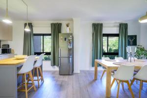 eine Küche und ein Esszimmer mit einem Tisch und einem Kühlschrank in der Unterkunft Stunning Duplex in Amadora in Amadora
