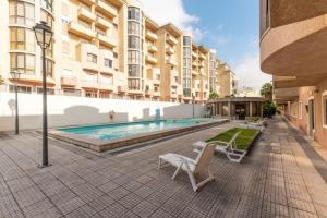 a swimming pool with lounge chairs next to a building at Stunning Duplex in Amadora in Amadora