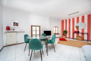 a dining room with a table and green chairs at Le Mandarine Apartments - Superior Apartment in Udine