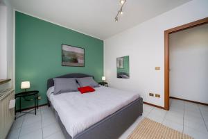 a bedroom with a bed with a red pillow on it at Le Mandarine Apartments - Superior Apartment in Udine