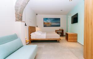 una camera da letto con un letto e un divano in una stanza di Etna Cottage Charming Rooms a Nicolosi