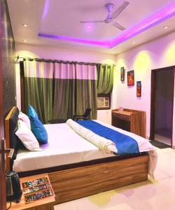 um quarto com uma cama grande e iluminação roxa em Goroomgo Maujis Villa Guest House Prayagraj Near Sangam Railway Station - Luxury Room Quality - Excellent Customer Service em Prayagraj