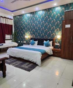 um quarto com uma cama grande e um cobertor azul em Goroomgo Maujis Villa Guest House Prayagraj Near Sangam Railway Station - Luxury Room Quality - Excellent Customer Service em Prayagraj
