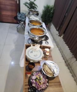 bufet z miskami jedzenia na stole w obiekcie Goroomgo Maujis Villa Guest House Prayagraj Near Sangam Railway Station - Luxury Room Quality - Excellent Customer Service w mieście Prayagraj