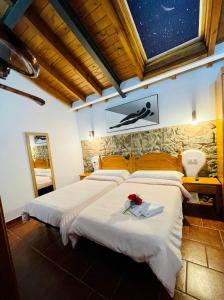 um quarto com duas camas com flores na parede em Hotel Restaurante La Navaliega em Oviedo
