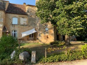 an old stone house with a sign in front of it at Château de Monsac in Monsac
