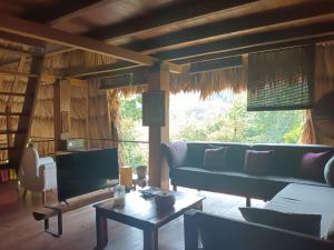 a living room with a couch and a table at Alice Guesthouse in El Remate