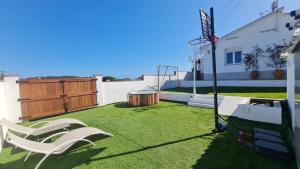 un patio trasero con un aro de baloncesto y césped en La Mediterranea, en Palafolls