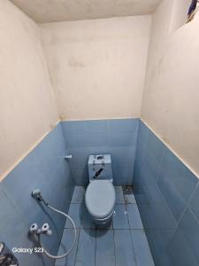 a blue bathroom with a toilet in a room at SYED FAMILY REST HOUSE in Karachi