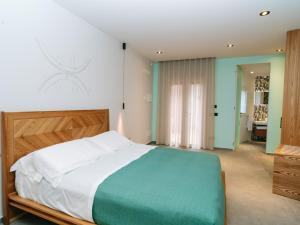 1 dormitorio con 1 cama grande con manta verde y blanca en Etna Cottage Charming Bed and breakfast en Nicolosi