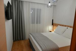 una camera con un grande letto e una finestra di Mouson House Luxury Apartments a Kavala