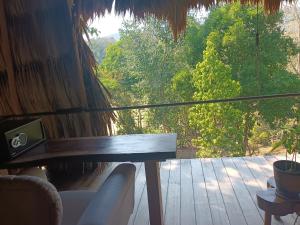 a balcony with a table and a view of trees at Alice Guesthouse in El Remate