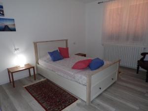 1 dormitorio con 1 cama con almohadas rojas y azules en Casa Vacanze Terra di Mezzo, en Invorio Inferiore