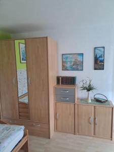 a bedroom with wooden cupboards and a bed at Ferienwohnung "Sonnenschein" 75 qm mit großem Garten im lausitzer Seenland in Drochow