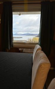 - une chambre avec un lit et une grande fenêtre dans l'établissement Aurora dream, à Skjervøy