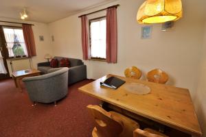 - un salon avec une table et des chaises en bois dans l'établissement Apartment 06 - Ferienresidenz Roseneck, 2 Schlafzimmer, mit Schwimmbad in Todtnauberg bei Feldberg, à Todtnauberg