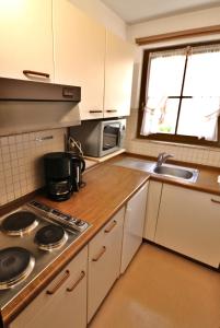 a small kitchen with a stove and a sink at Apartment 06 - Ferienresidenz Roseneck, 2 Schlafzimmer, mit Schwimmbad in Todtnauberg bei Feldberg in Todtnauberg