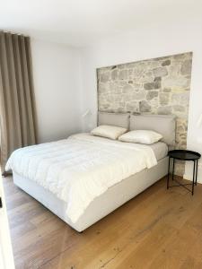 a bedroom with a large bed with a stone wall at Casa Matko in Kostanjevica na Krasu