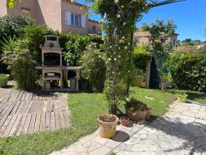 ogród z odkrytym piekarnikiem w trawie w obiekcie magnifique maison 6 personne piscine w mieście Antibes