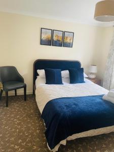 una camera con un letto blu e una sedia di Wallace House a Fort William