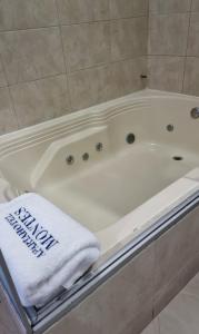a white bath tub with a white towel on it at ApartaHotel Montes Medellin in Medellín