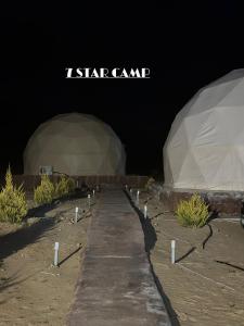 7star camp في وادي رم: خيمتان متصلتان في الصحراء في الليل