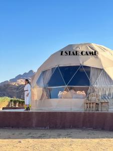 7star camp في وادي رم: رجل يقف في خيمة في الصحراء