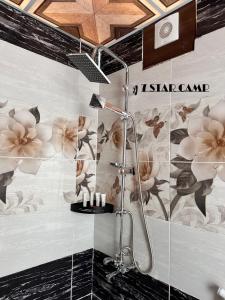 7star camp في وادي رم: حمام مع دش مع الزهور على الحائط