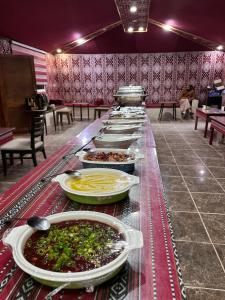 a buffet line with plates of food on a table at 7star camp in Wadi Rum