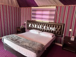 a bedroom with a bed with a sign on it at 7star camp in Wadi Rum