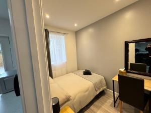 Dormitorio pequeño con cama y espejo en Cosy Budget Room, en Beckenham