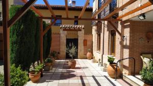 einen Innenhof mit Topfpflanzen und einem Backsteingebäude in der Unterkunft Apartamento céntrico "Casa Belinda" in Toro