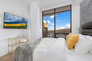 a bedroom with a white bed and a large window at Skyview 2 Bedroom Penthouse in Los Angeles