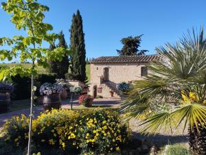 a building in a garden with flowers and trees at Rocca degli Olivi in San Gimignano