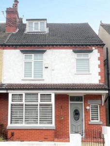 a white and red brick house with a black roof at Lovely 5BR Home in Manchester. Close to the City in Manchester