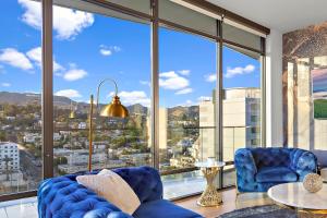 a living room with a blue couch and a large window at Skyview 2 Bedroom Penthouse in Los Angeles