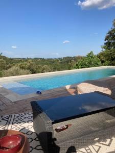 - une télévision assise sur une terrasse à côté d'une piscine dans l'établissement Idyllic Roulotte, à Les Assions