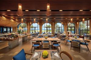 a restaurant with tables and chairs and windows at Aqua Vista Hoi An Beachfront Villas in Hoi An +67 photos