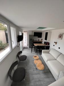 a living room with a couch and chairs and a table at Joli duplex in Colombes