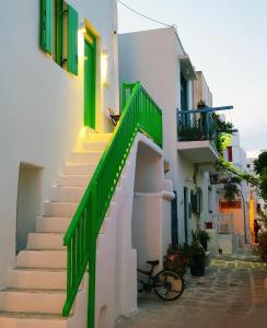 a staircase in a building with a green door and a bike at Rania's Home in Mikonos