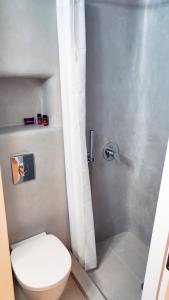 a bathroom with a white toilet and a shower at Rania's Home in Mikonos