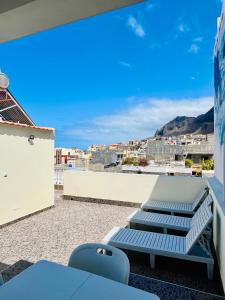 einen Balkon mit Stühlen und Stadtblick in der Unterkunft Casa BB&Djassi in Ponta do Sol