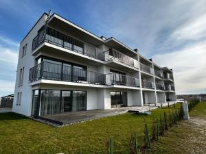 a white building with balconies and a yard at Palanga - Šventosios pajūrio namai in Palanga