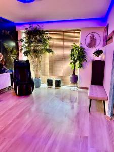 a room with potted plants and a chair and purple lights at Apartment Aura Spa Wesel in Wesel