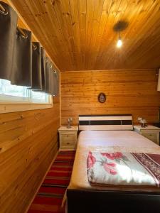 a bedroom with a bed in a wooden room at Origjina Farm in Përmet