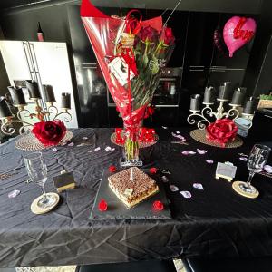 una mesa con un jarrón encima de una mesa con rosas en Loft 80m2 avec sauna, spa, table de massage et billard en Milhaud