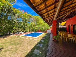 un patio al aire libre con piscina, mesa y sillas en Casa do Lord - Natú en Mata de Sao Joao