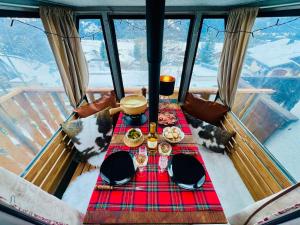 a table with food on it in a room with windows at Serpolet - Studio loft - Sauna in Leysin