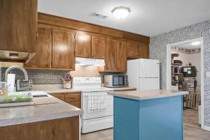 uma cozinha com armários de madeira e electrodomésticos brancos em The McPherson em Charleston
