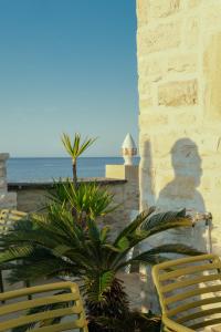 a shadow of a man standing next to two chairs at S. Martin Hotel in Giovinazzo
